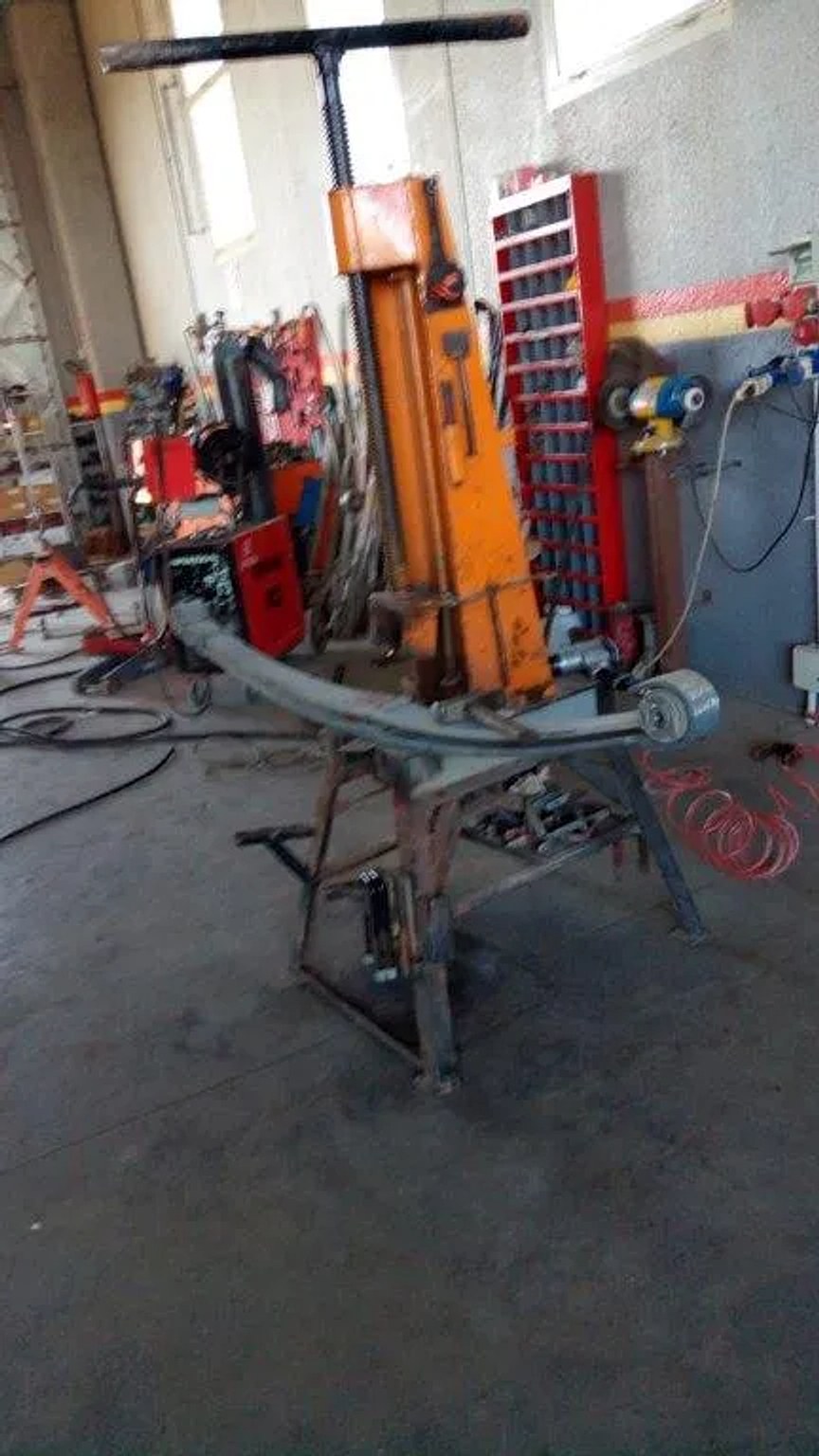 Banco di lavoro con la pressa idraulica per il montaggio delle molle a balestra.