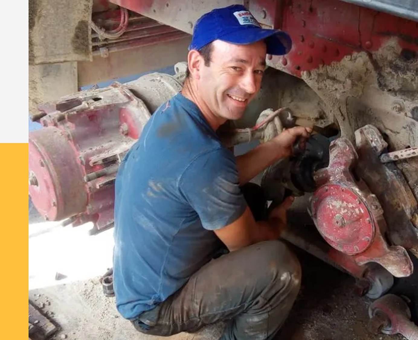 Un tecnico dell'officina al lavoro su un pacco di molle a balestra verniciate di rosso.