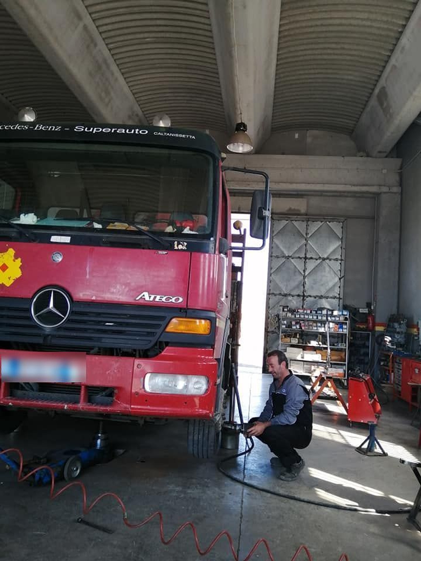 Un autocarro Mercedes in officina, sollevato per l'intervento sulle sospensioni.